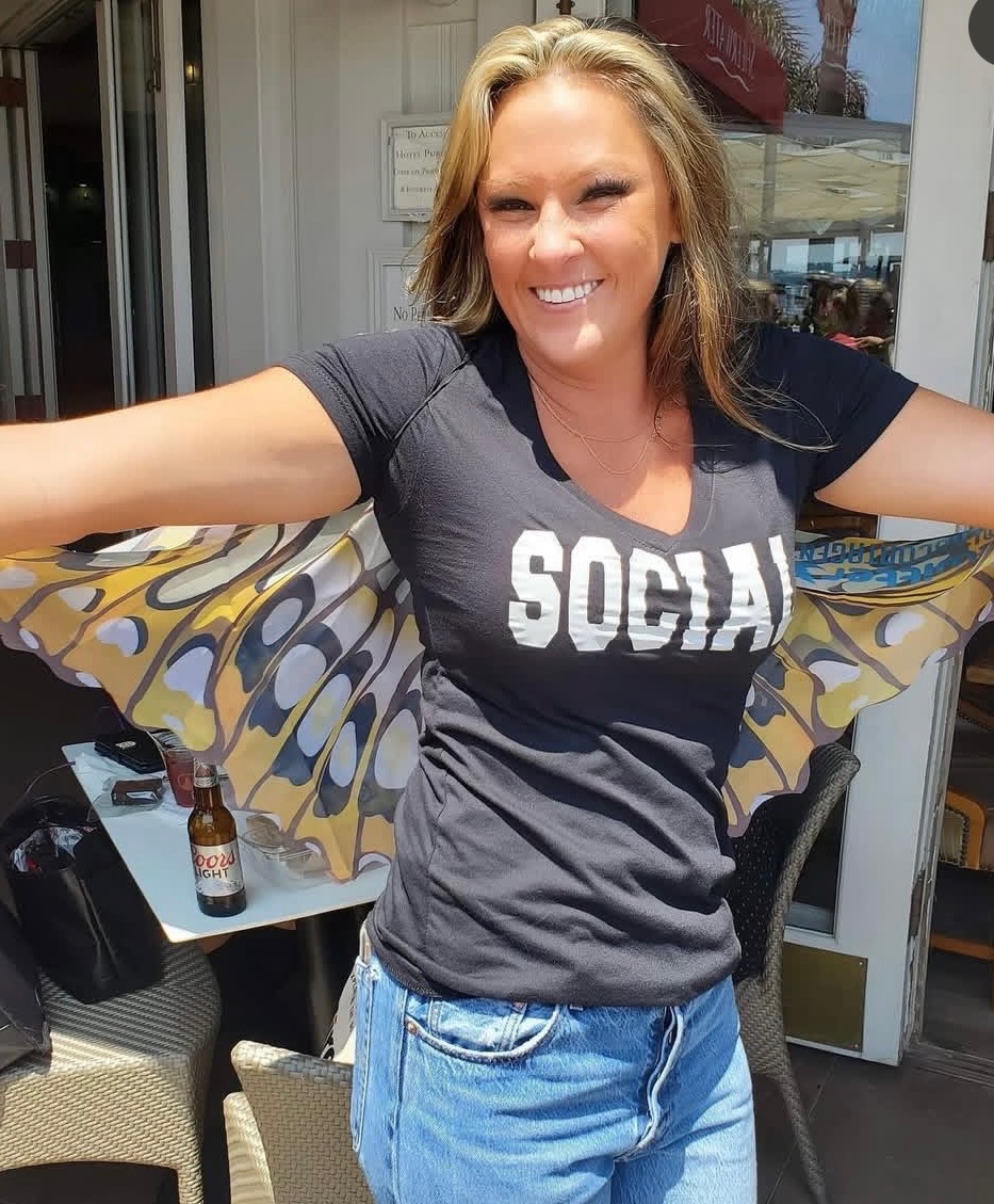 Julie, founder of Social Butterfly Property Services, smiling with butterfly wings